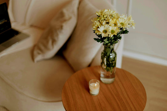 Glass vase with wildflowers on a wooden table bathed in soft summer light.