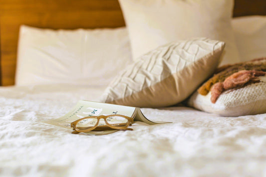 A cozy morning scene with soft blankets and warm natural light, inviting rest without reason.